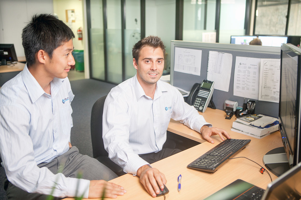 Engineers collaborating in an office environment on forensic engineering projects.